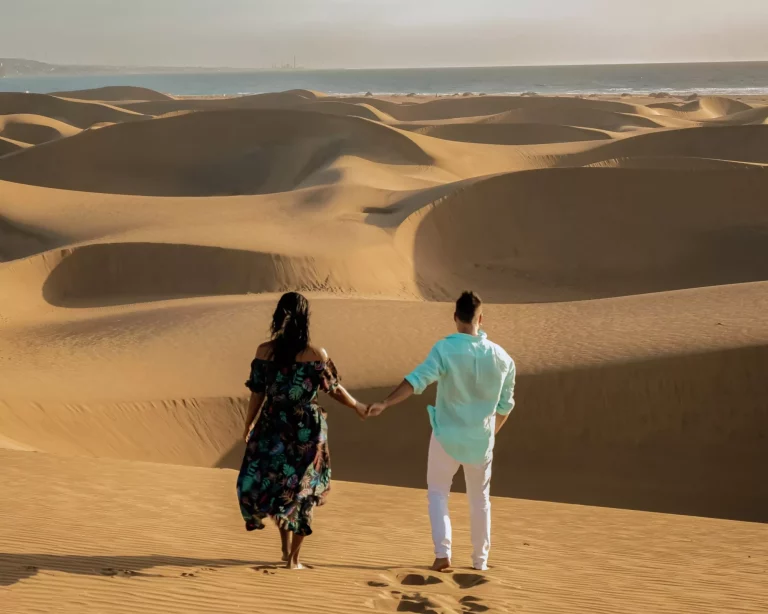 Пара гуляет по песчаным дюнам в пустыне Маспаломас Гран-Канария, мужчина и женщина наблюдают за восходом солнца в пустыне Маспаломас Гран-Канария