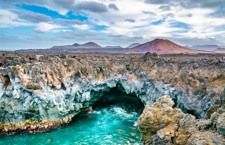 Fantastisk udsigt over lavahulerne Los Hervideros og vulkanerne på Lanzarote, en populær turistattraktion. Beliggenhed: Lanzarote, De Kanariske Øer, Spanien. Kunstnerisk billede. Skønhedens verden. Rejsekoncept.
