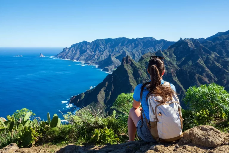 Kvinnelig turgåer betrakter vakkert kystlandskap. - Tenerife, Kanariøyene, Spania. utsikt over kysten og fjellet Anaga.